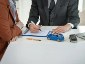 man signing a form in front of a woman
